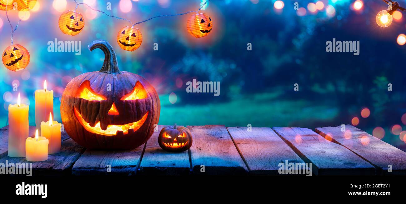 Zucca con candele sul tavolo in giardino - Halloween all'aperto Foto Stock