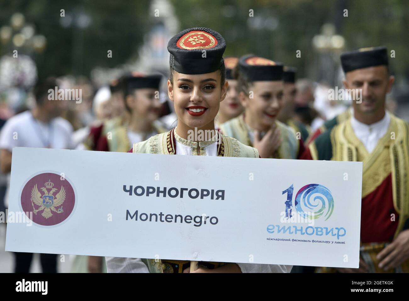 Non esclusiva: LVIV, UCRAINA - 20 AGOSTO 2021 - UNA donna in costume montenegrino sorride durante la processione che segna l'apertura dell'Etnovyr 2021 Foto Stock
