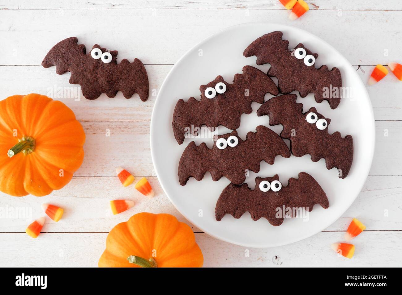 Biscotti di Halloween, vista dall'alto con zucche su sfondo di legno bianco Foto Stock