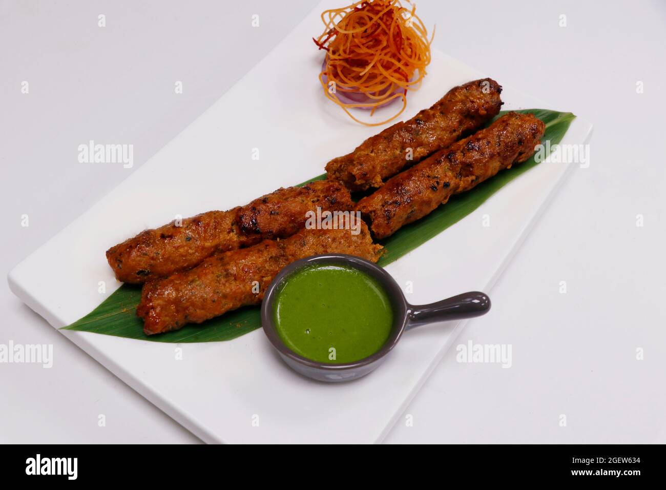 kebab di agnello seekh (spiedino di carne di montone tritata) servito con chutney di menta, cibo indiano di strada Foto Stock