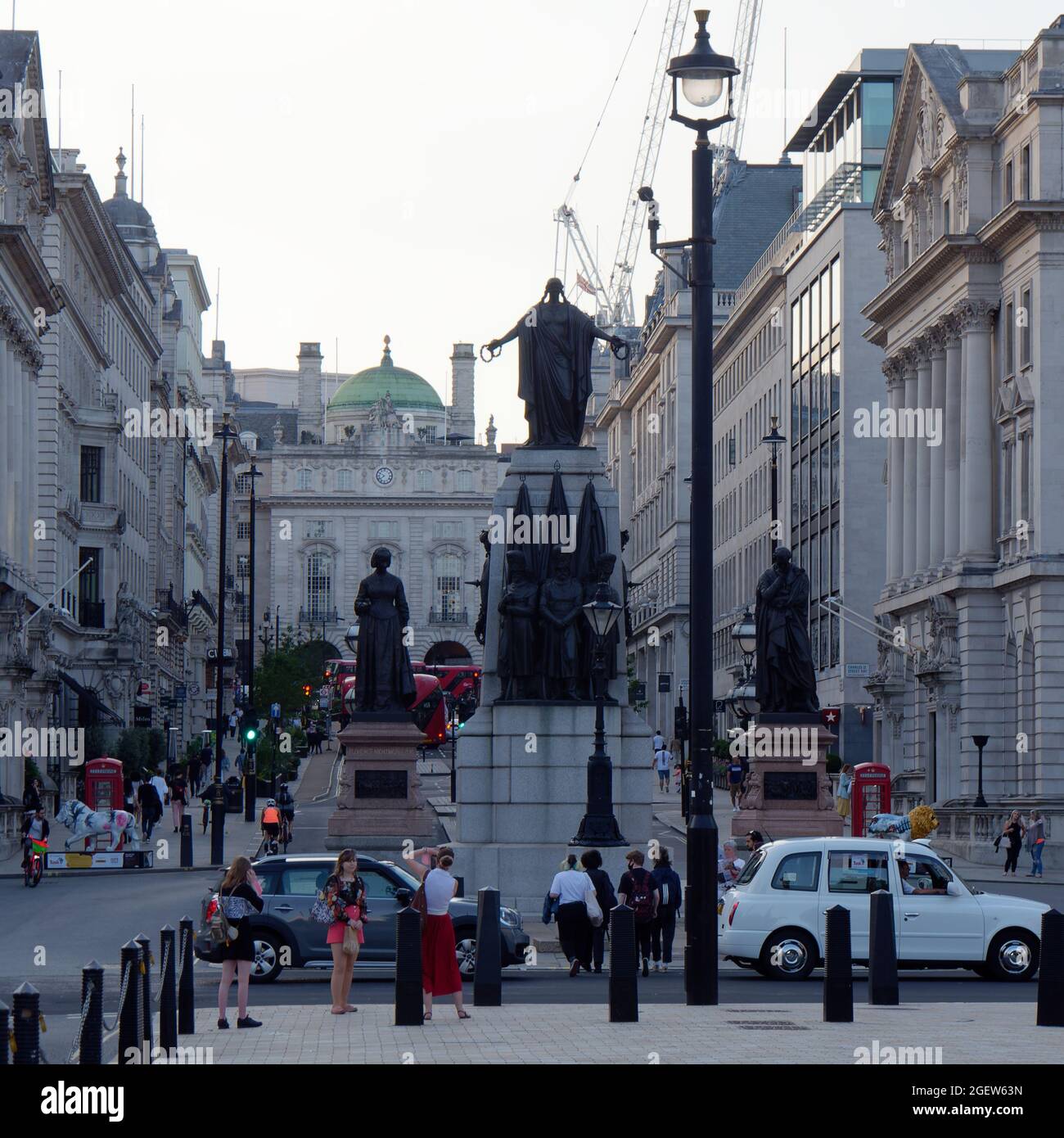 Waterloo Place. Donne che hanno foto scattate dal Guards Crimea War Memorial. Piccadilly Circus sullo sfondo. Foto Stock