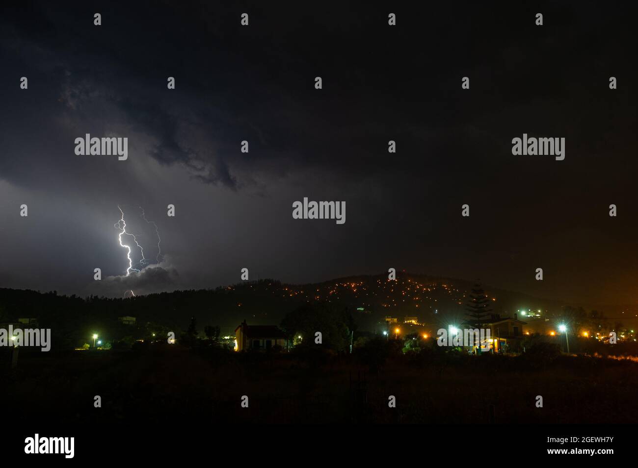 La forza della natura che brucia la terra. Piccoli vasi di fuoco ancora in fiamme, mentre una tempesta di tuono sta arrivando nel nord Evia bruciato, Grecia il 2021 agosto Foto Stock