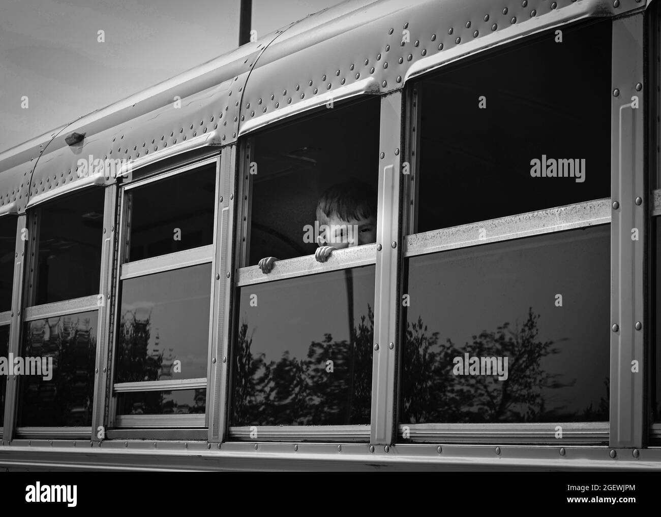 Un bambino afghano guarda attraverso una finestra di autobus alla base aerea di Ramstein, Germania, 20 agosto 2021. La base aerea di Ramstein fornisce alloggio sicuro e temporaneo per gli evacuati qualificati provenienti dall'Afghanistan come parte dell'operazione Allees Refuge. Questa operazione sta facilitando l'evacuazione rapida e sicura dei cittadini statunitensi, dei richiedenti di visti speciali per immigrati e di altri afghani a rischio dall'Afghanistan. Gli evacuati riceveranno supporto, come alloggio temporaneo, cibo, screening medico e trattamenti e altro ancora, mentre soggiornano presso la base aerea di Ramstein mentre si preparano per i movimenti successivi verso le loro destinazioni finali. (STATI UNITI Presa d'aria Foto Stock