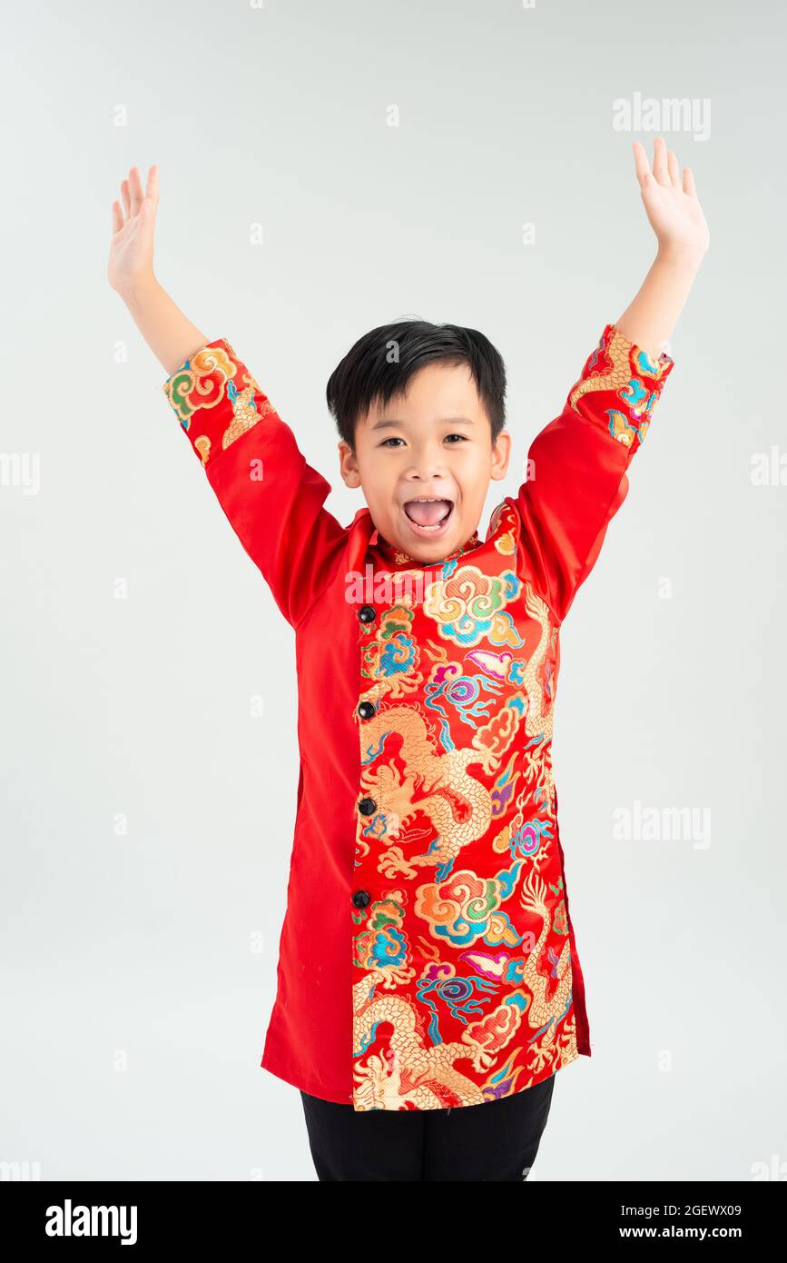 Carino asiatico bambino è sorpresa e così felice di esso in ao dai su sfondo bianco isolato Foto Stock