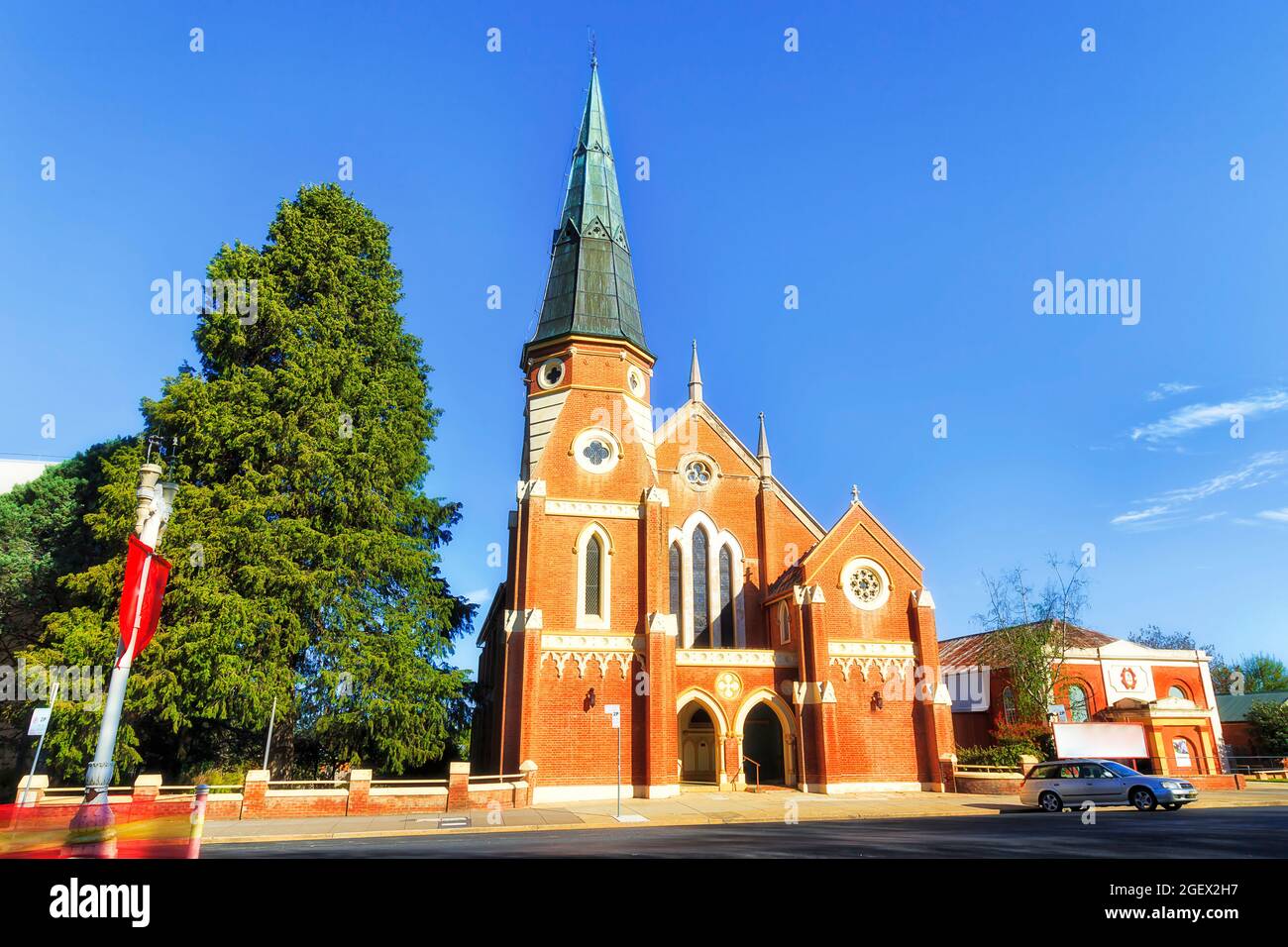 Strada locale nella città di Bathurst con storico edificio in mattoni rossi che unisce la chiesa sotto il cielo blu. Foto Stock