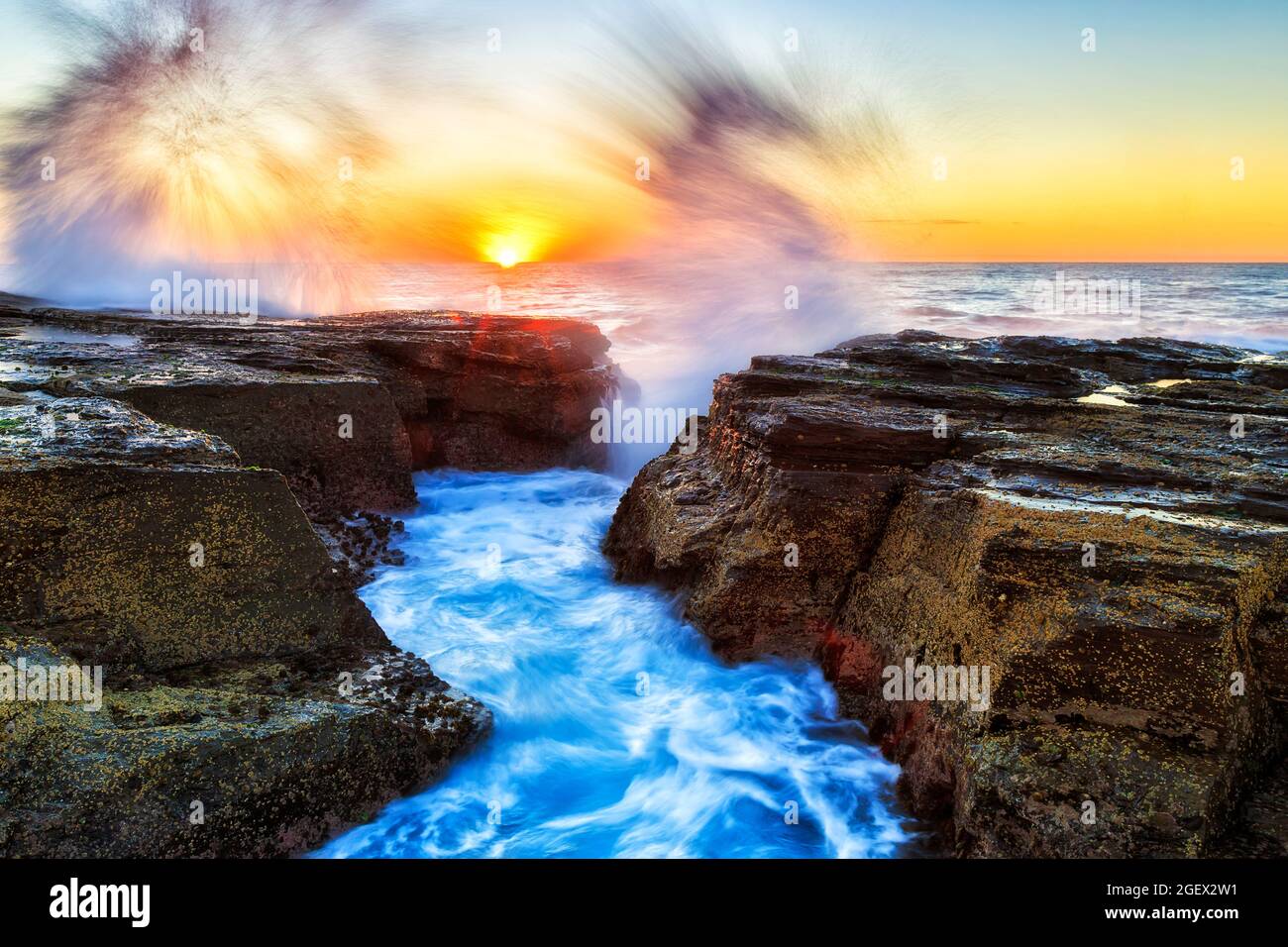 L'alta onda si spruzza sulle rocce di arenaria alle spiagge settentrionali di Sydney all'alba - scenico oceano Pacifico stagcape. Foto Stock