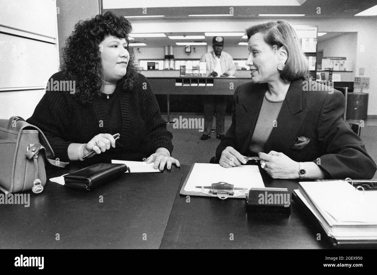 Austin Texas USA, circa 1993: Responsabile del prestito femminile presso la Nation's Bank, a destra, parla al cliente di finanziamento. ©Bob Daemmrich Foto Stock