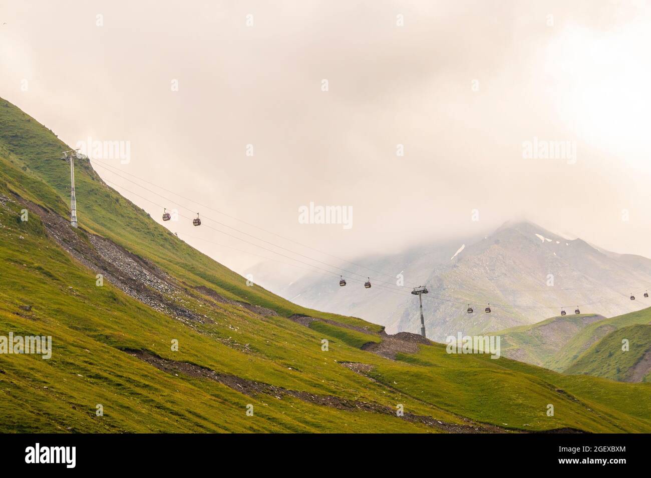 Le funivie si trovano nelle montagne settentrionali della Georgia in un giorno di nebbia che collega le città con le relazioni sugli sci vicino a Stepantsminda vicino alla Russia Foto Stock
