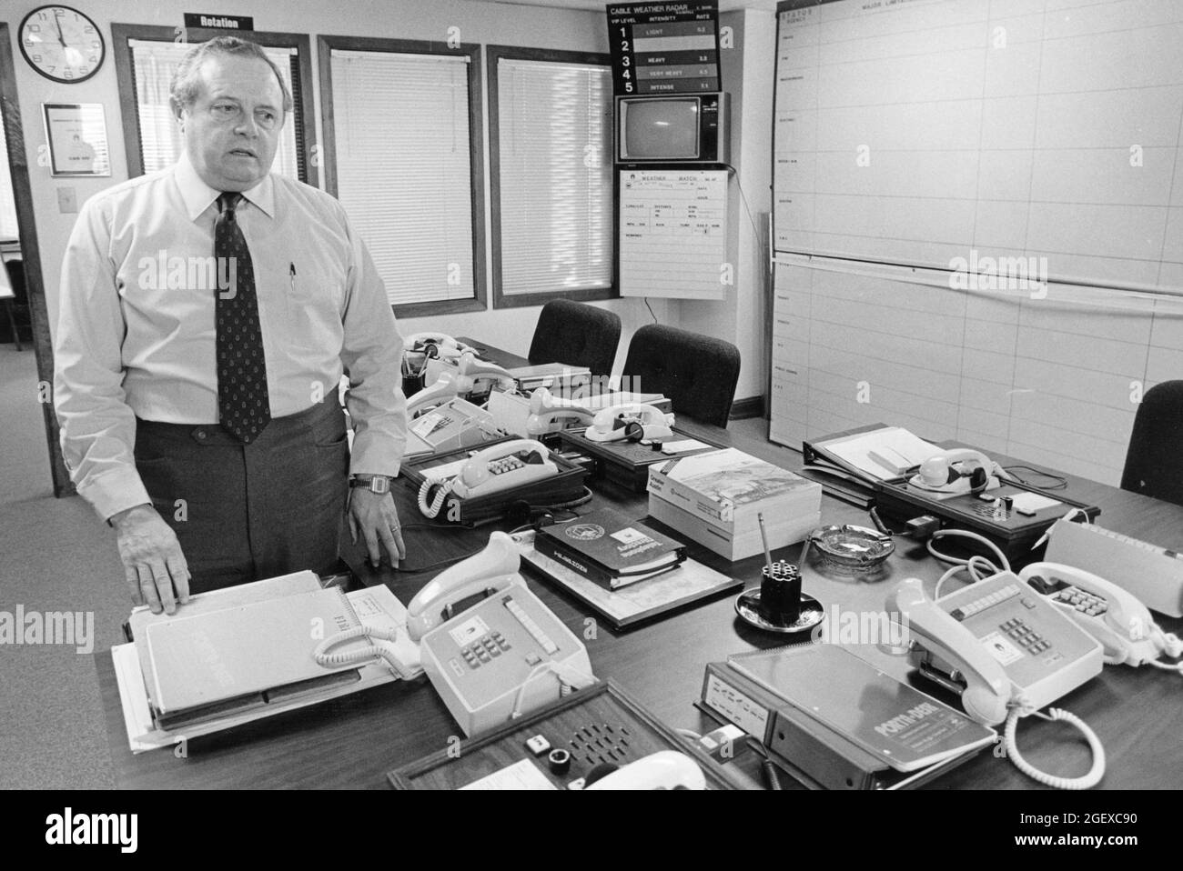 Austin Texas USA, circa 1987: Il direttore del centro operativo di emergenza della città di Austin si trova in una sala conferenze piena di telefoni. ©Bob Daemmrich Foto Stock