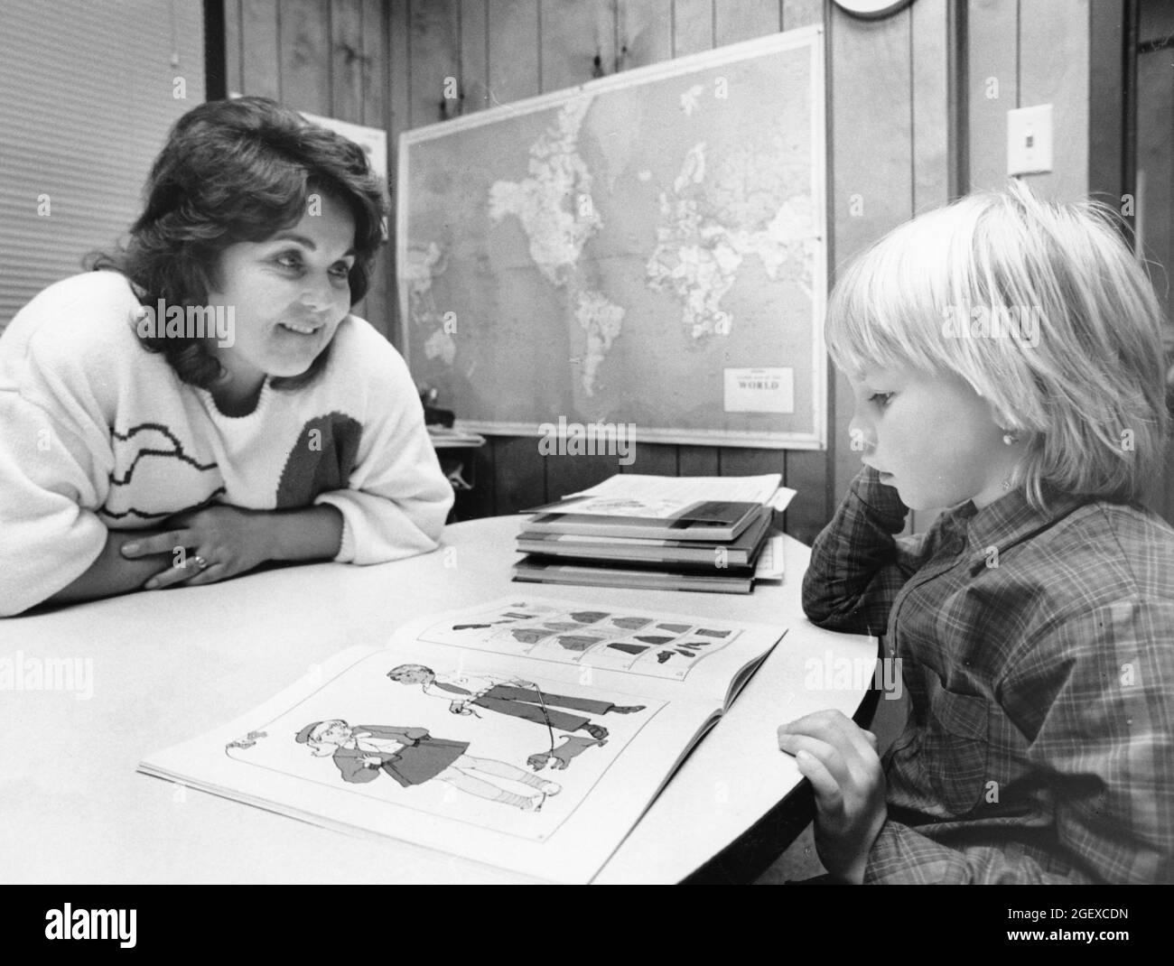 Austin Texas USA, circa 1991: Insegnante di scuola elementare pubblica femminile che lavora con gli studenti di inglese come seconda lingua (ESL) nella sua classe. ©Bob Daemmrich Foto Stock