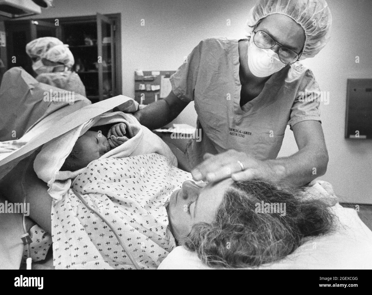Austin Texas USA, 1982: La storia del parto che ha funzionato nell'americano-statesman di Austin in 1982. L'infermiere che assiste presenta il neonato ricalcato alla madre. File 82-48 Box #12 la nascita era 6-2-1982. ©Bob Daemmrich Foto Stock