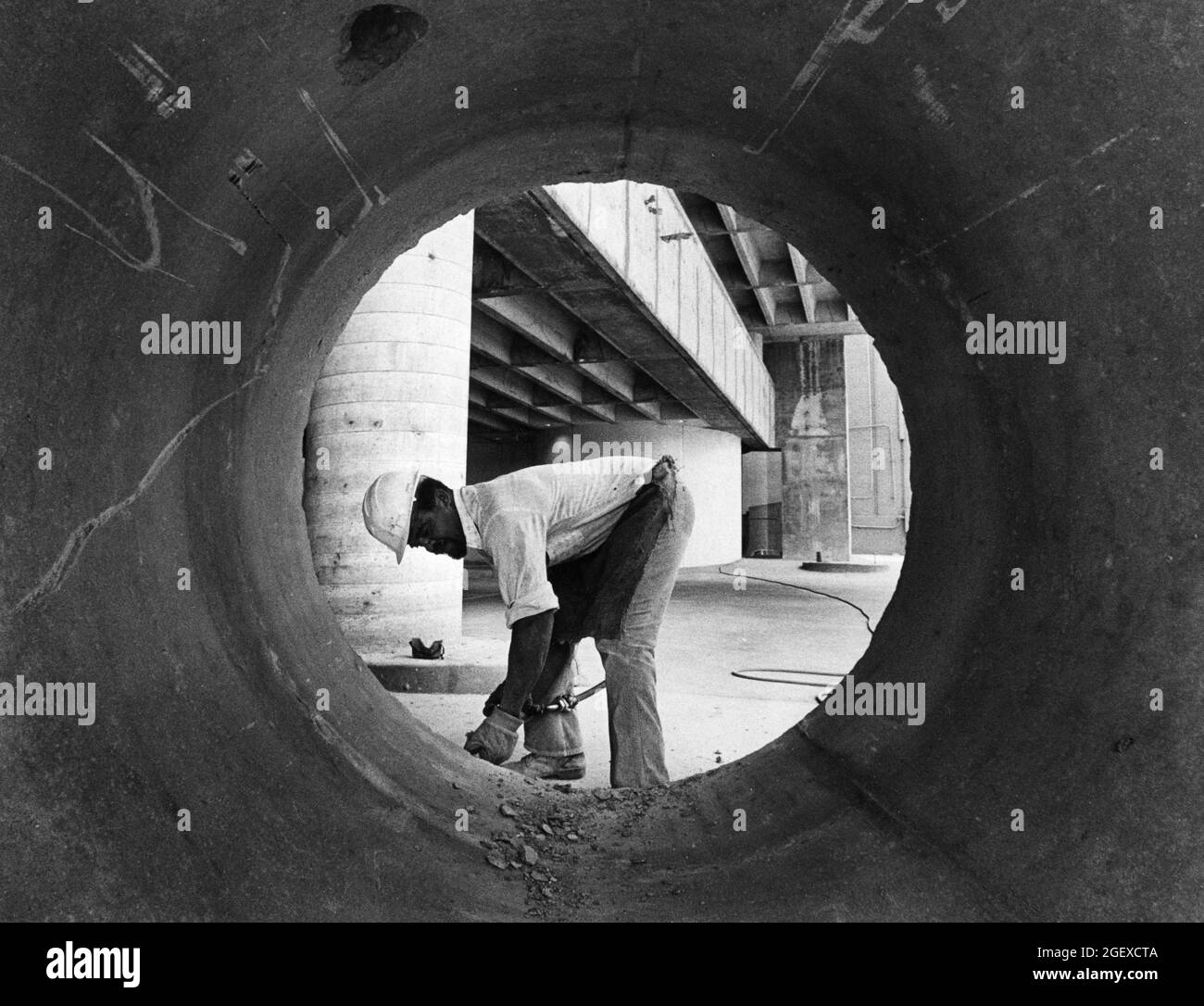 Austin Texas USA, circa 1984: Uomo che indossa elmetto lavora su progetto di costruzione fogna su Congress Avenue. ©Bob Daemmrich Foto Stock