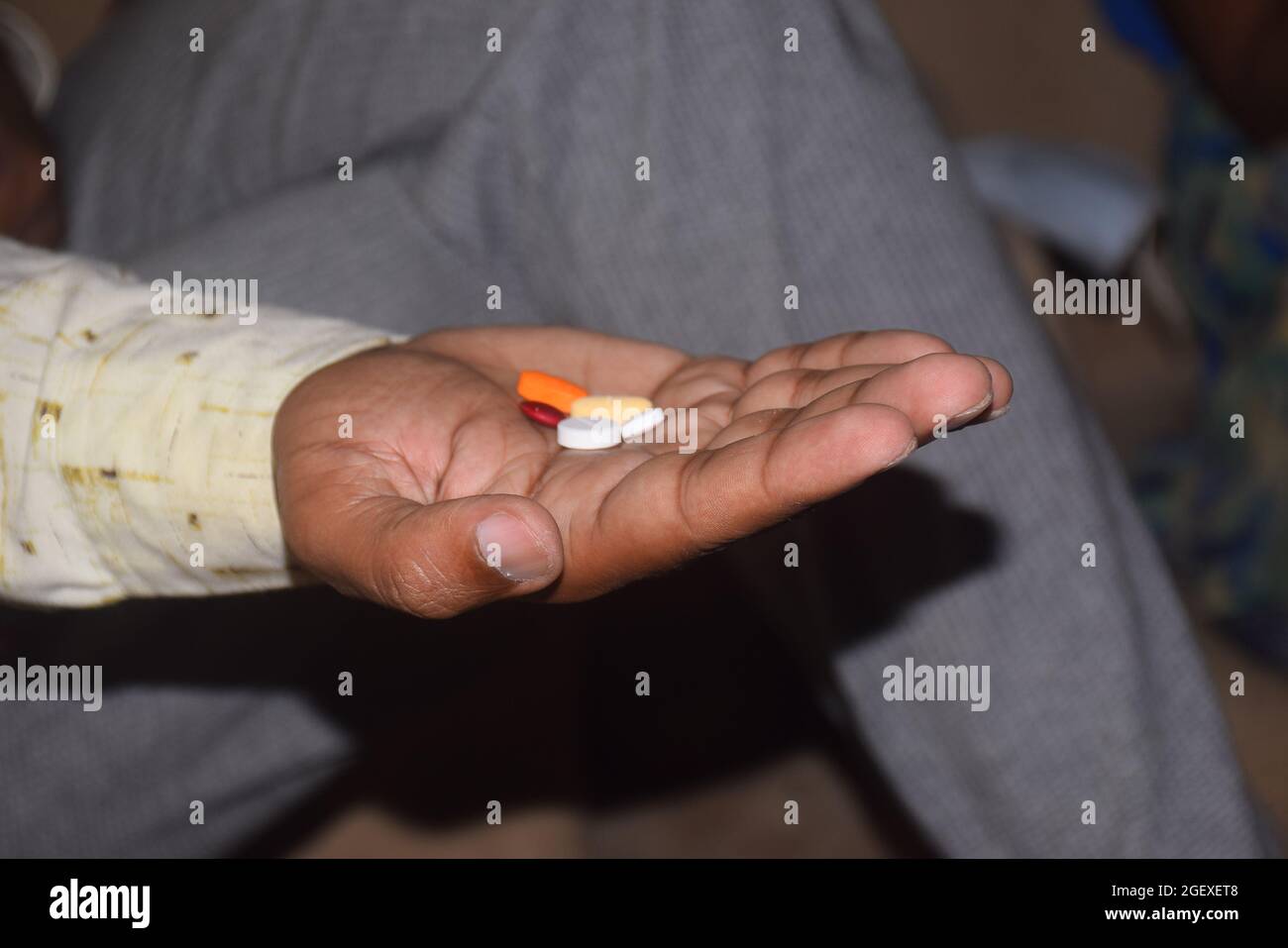 primo piano la mano del giovane uomo con pillole e bicchiere d'acqua, sta per prendere qualche medicina Foto Stock