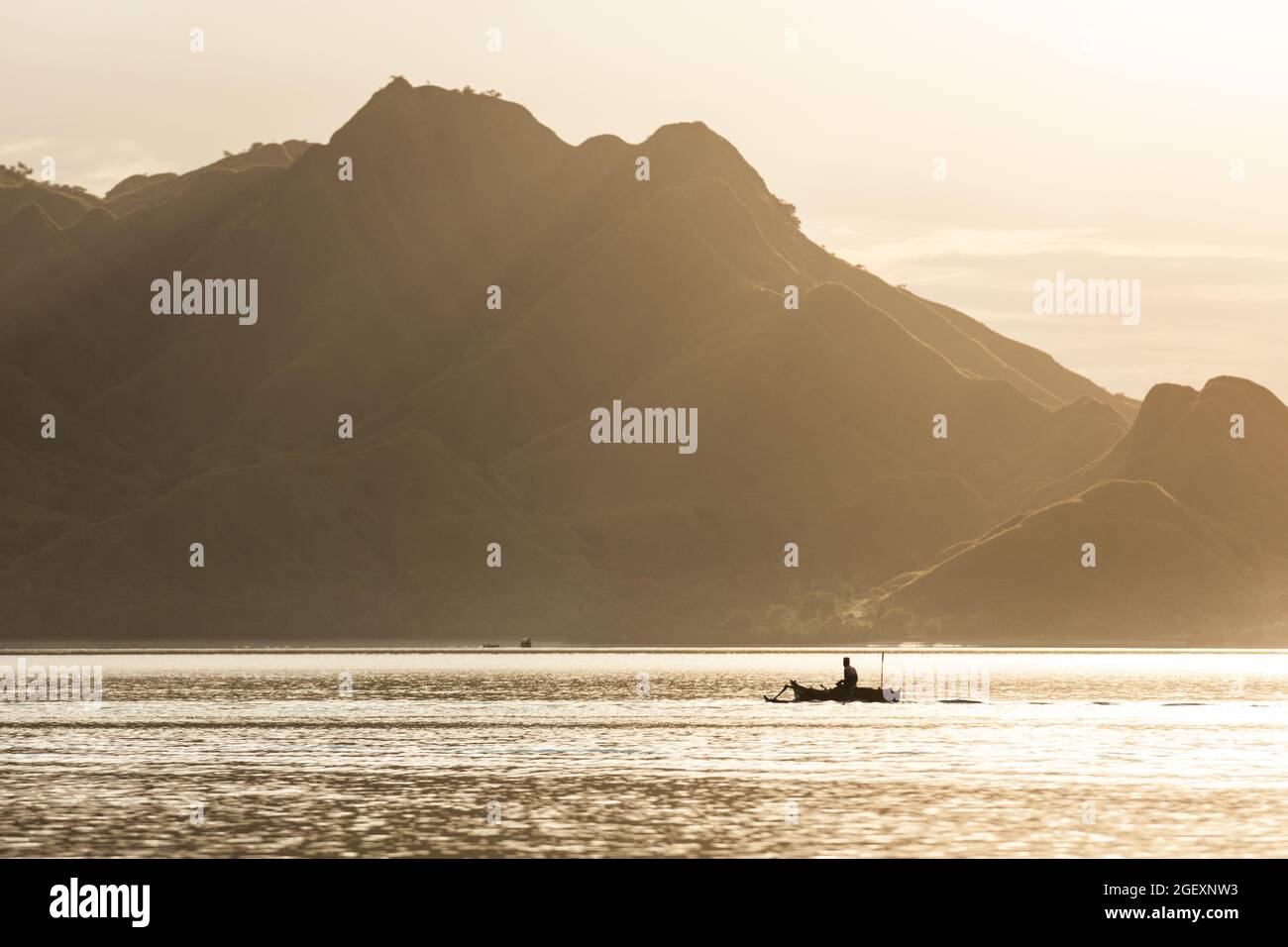 Silhouette di un boatman che rema nel mare dorato Foto Stock