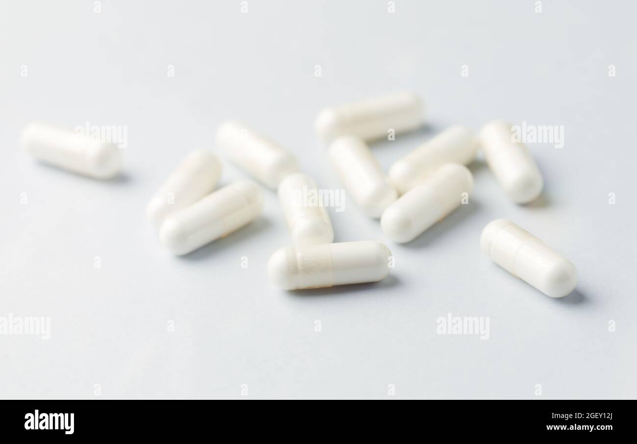 Le capsule di arginina. Carta luminoso dello sfondo. Close up. Foto Stock