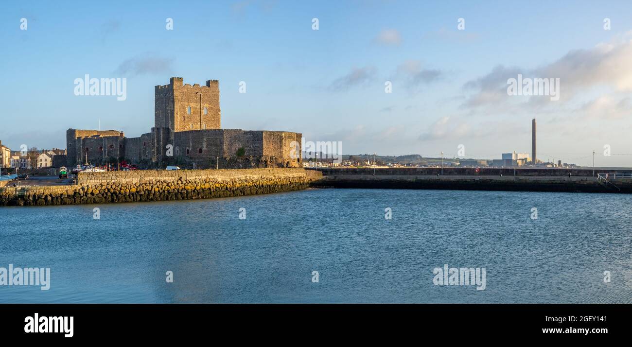 Panorama del castello medievale normanno a Carrickfergus vicino Belfast, Irlanda del Nord, con porticciolo e frangiflutti in inverno. Vecchia centrale elettrica sul retro Foto Stock