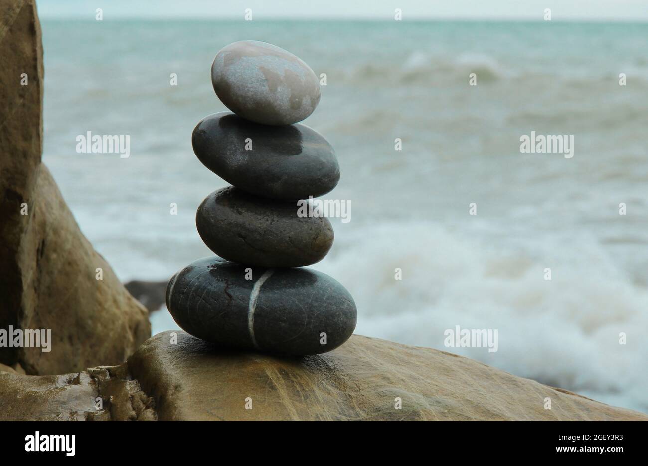Piramide in pietra sullo sfondo di un mare infuriante Foto Stock