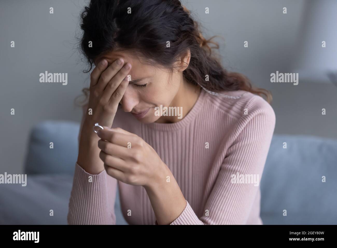 Closeup donna tenuta anello piangere passa attraverso il divorzio Foto Stock