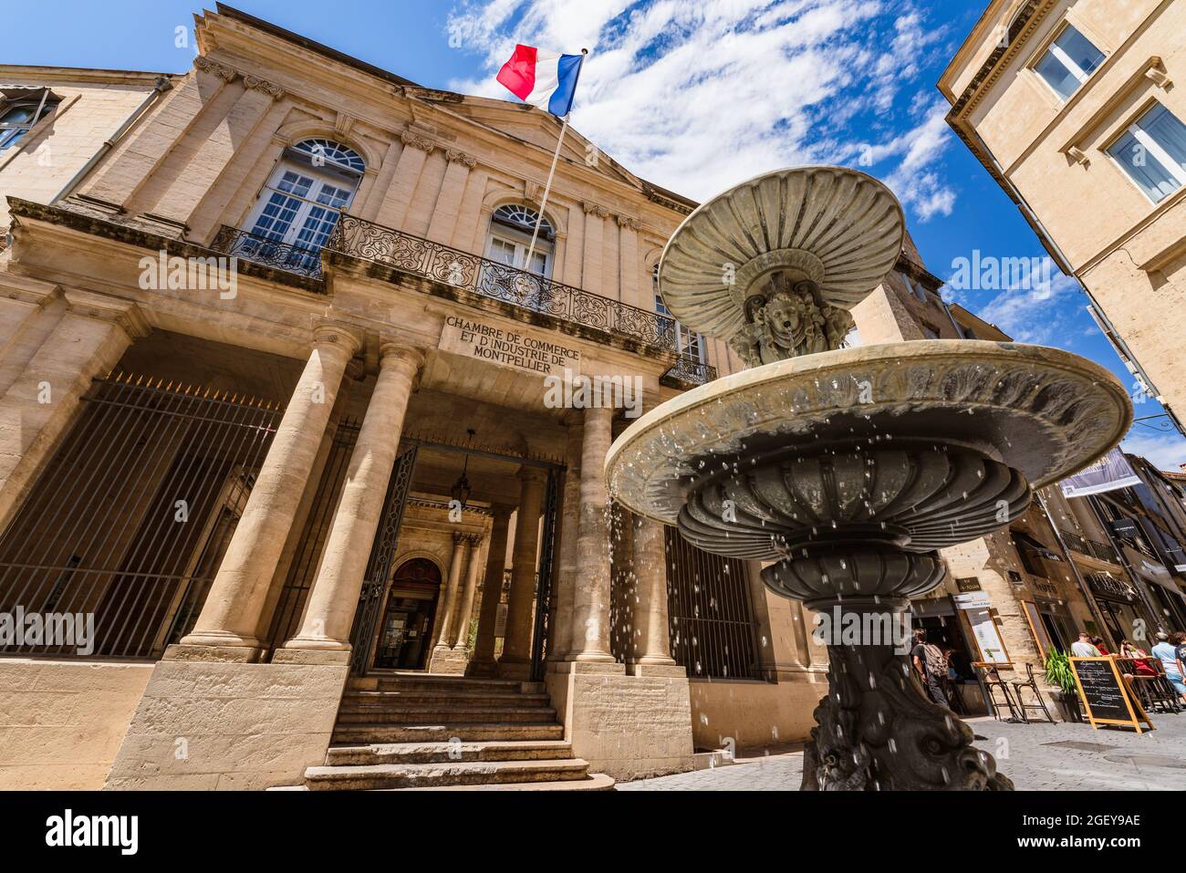 Montpellier, Francia. 5 agosto 2021. Vista ad angolo basso della Camera di Commercio e una fontana. Foto Stock