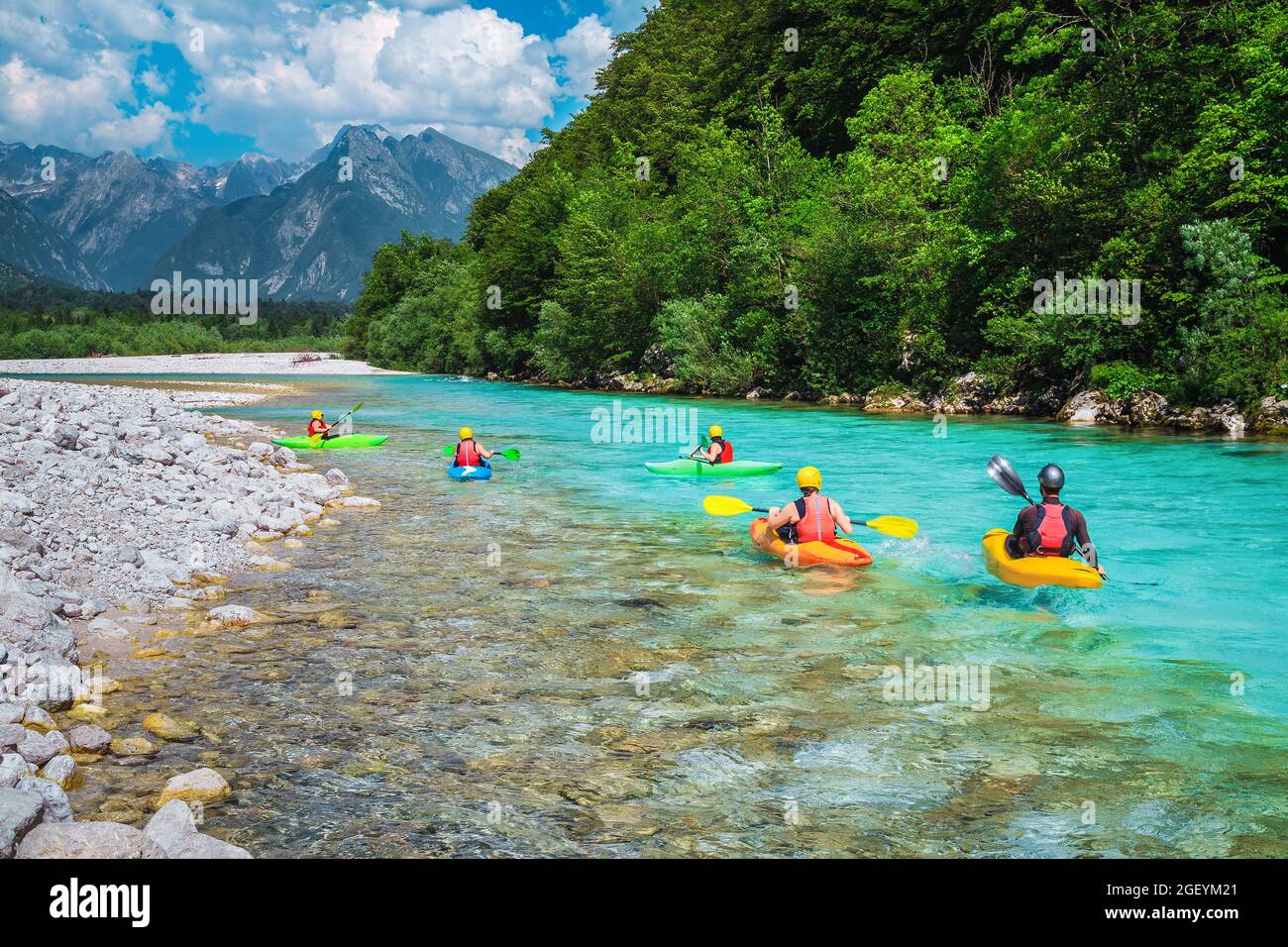 Maestoso luogo di rafting e kayak sul fiume. Kayak attivi in coloratissimo giubbotto salvagente che si allena e si esercita sul fiume Soca, B, color turchese Foto Stock