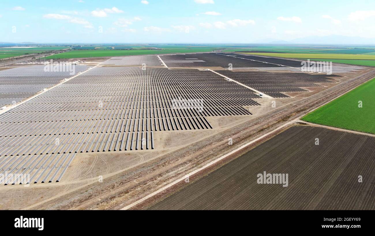 vista aerea drone di una vasta fattoria di energia solare con campi agricoli arati in campagna. Foto Stock