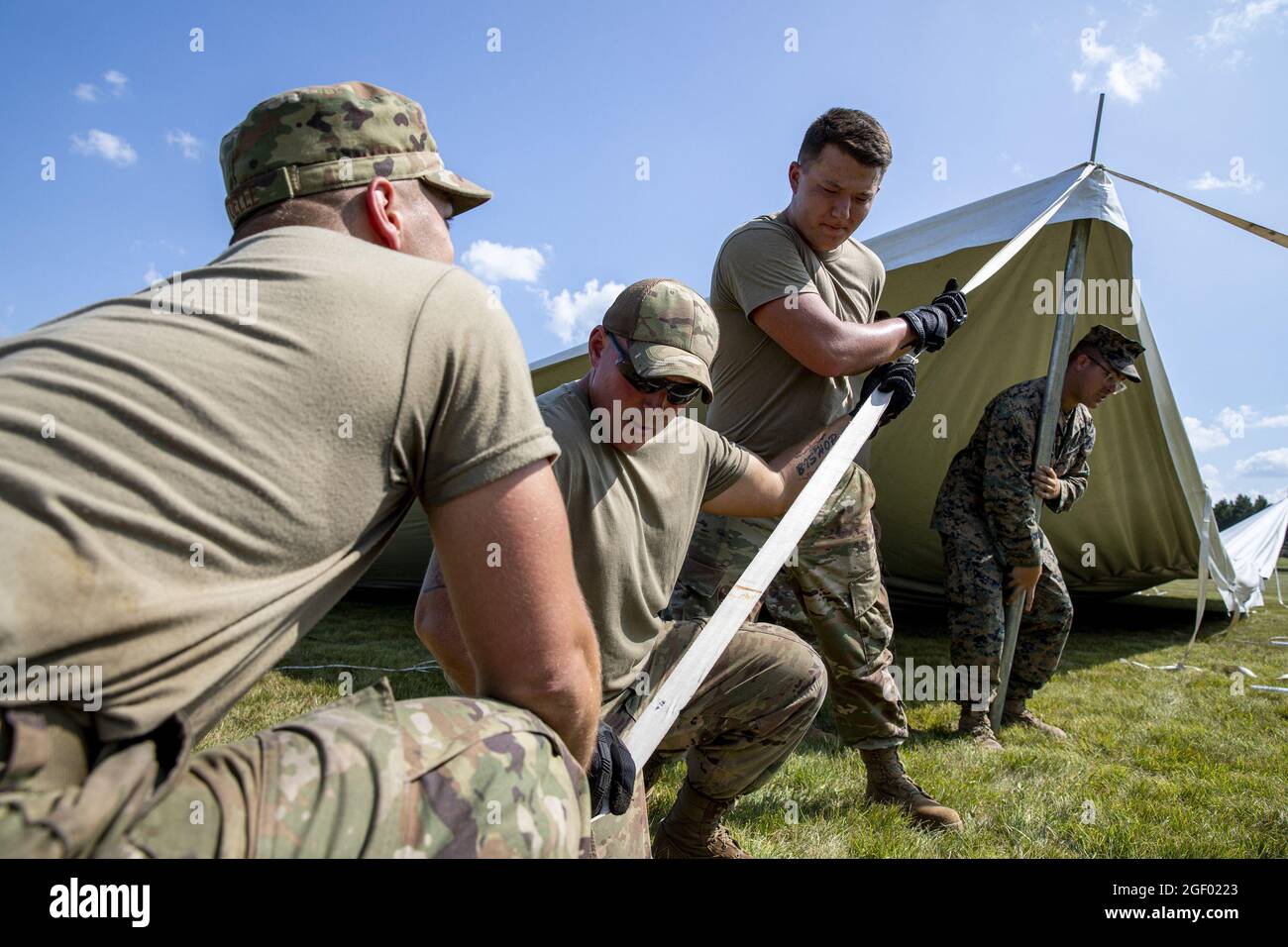 I Marines degli Stati Uniti dal supporto dell'ala marina Squadron 471 e gli Airmen della Guardia Nazionale aerea degli Stati Uniti dal centro di addestramento di preparazione di combattimento di campo di Volk (CRTC) lavorano insieme per sollevare le tende di ricezione per l'arrivo degli evacuati afghani alla base di Guardia Nazionale aerea di campo di Volk, Wisconsin, il 19 agosto 2021. Il Dipartimento della Difesa, a sostegno del Dipartimento di Stato, fornisce trasporto e alloggio temporaneo a sostegno dell'operazione Allees Refuge. Questa iniziativa segue l'impegno dell'America nei confronti dei cittadini afghani che hanno aiutato gli Stati Uniti e fornisce loro un sostegno essenziale e sicuro Foto Stock