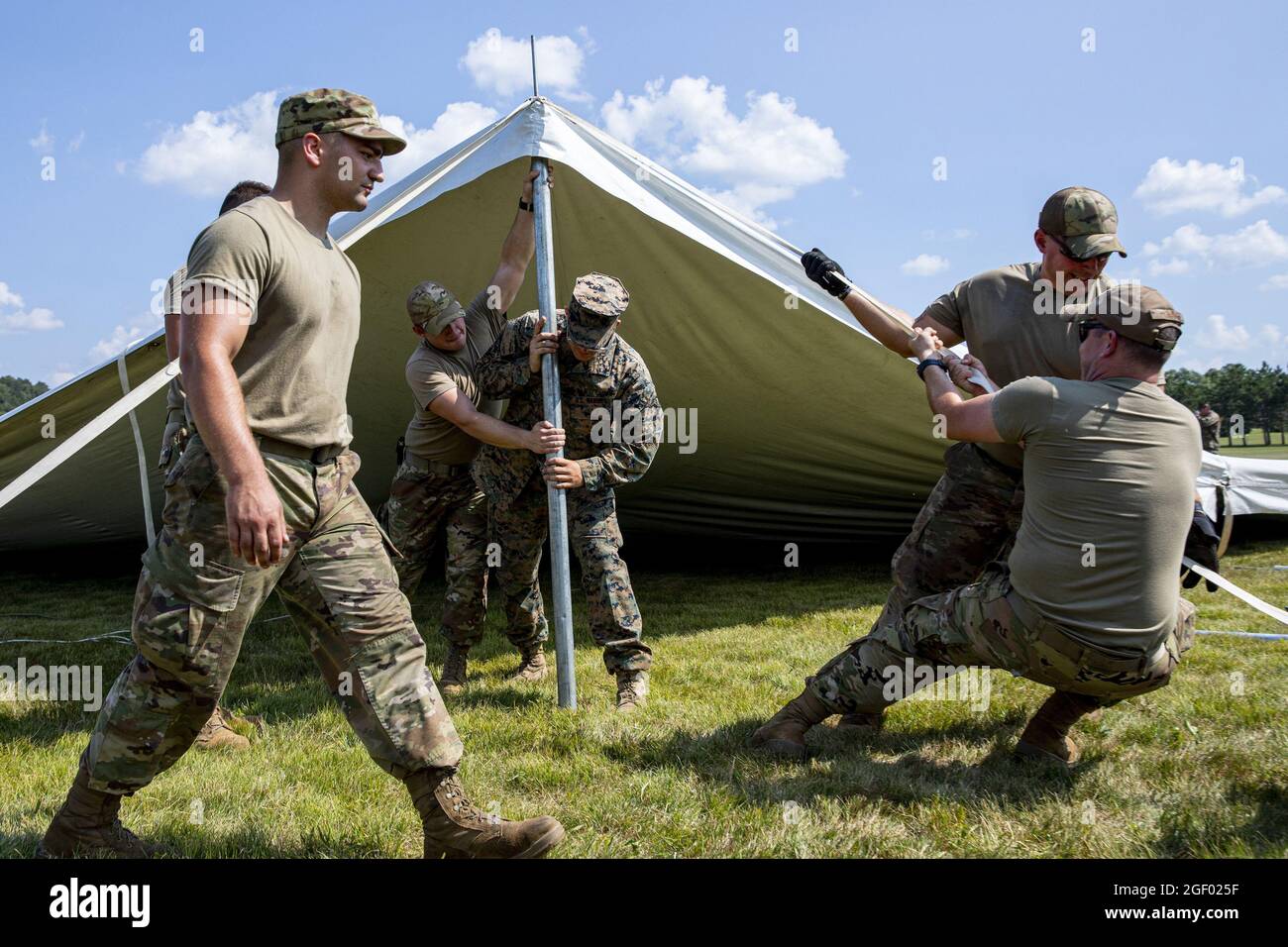 I Marines degli Stati Uniti dal supporto dell'ala marina Squadron 471 e gli Airmen della guardia nazionale dell'aria degli Stati Uniti dal centro di addestramento di preparazione di combattimento di campo di Volk (CRTC) lavorano insieme per aumentare le tende di ricezione per l'arrivo degli afghani alla base di guardia nazionale dell'aria di campo di Volk, Wisconsin, il 19 agosto 2021. Il Dipartimento della Difesa, a sostegno del Dipartimento di Stato, fornisce trasporto e alloggio temporaneo a sostegno dell'operazione Allees Refuge. Questa iniziativa segue l'impegno dell'America nei confronti dei cittadini afghani che hanno aiutato gli Stati Uniti e fornisce loro un sostegno essenziale per un luogo sicuro Foto Stock