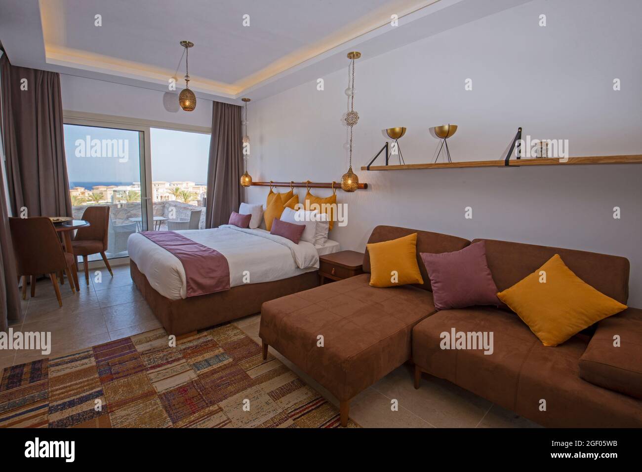 Soggiorno zona soggiorno nel lussuoso monolocale mostra casa con arredamento di design interno con balcone vista mare e letto matrimoniale Foto Stock