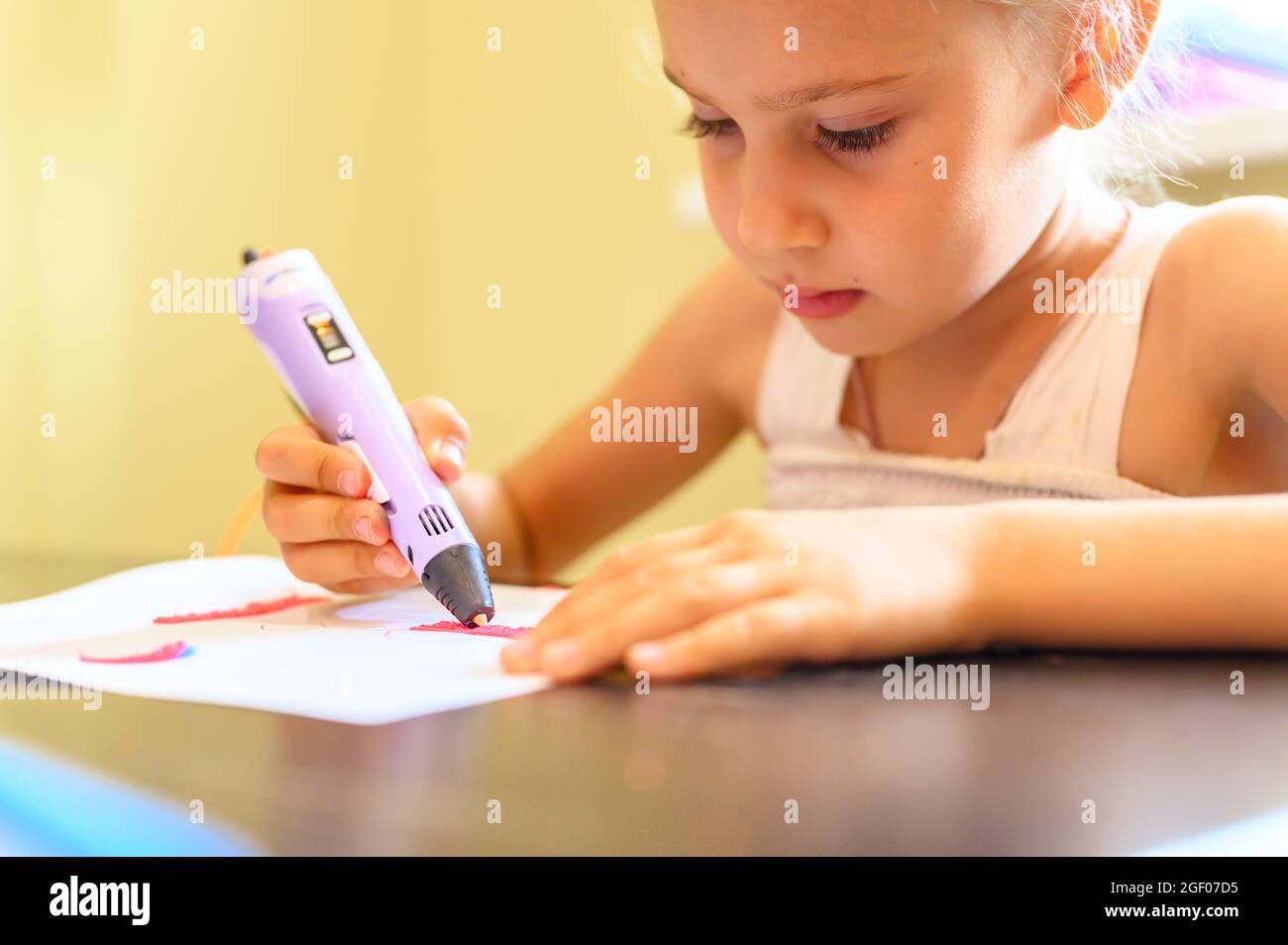 piccola bambina di sette anni disegna con una penna 3d e plastica a casa.  creatività e fai da te dei bambini Foto stock - Alamy