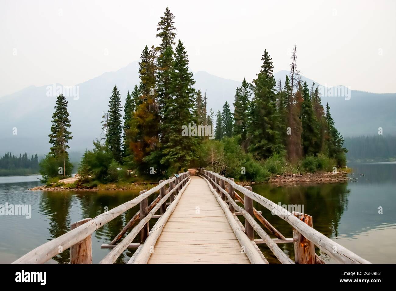 Primo piano di un ponte pedonale in legno che conduce ad una piccola isola sul lago Pyramid a Jasper, Alberta Foto Stock