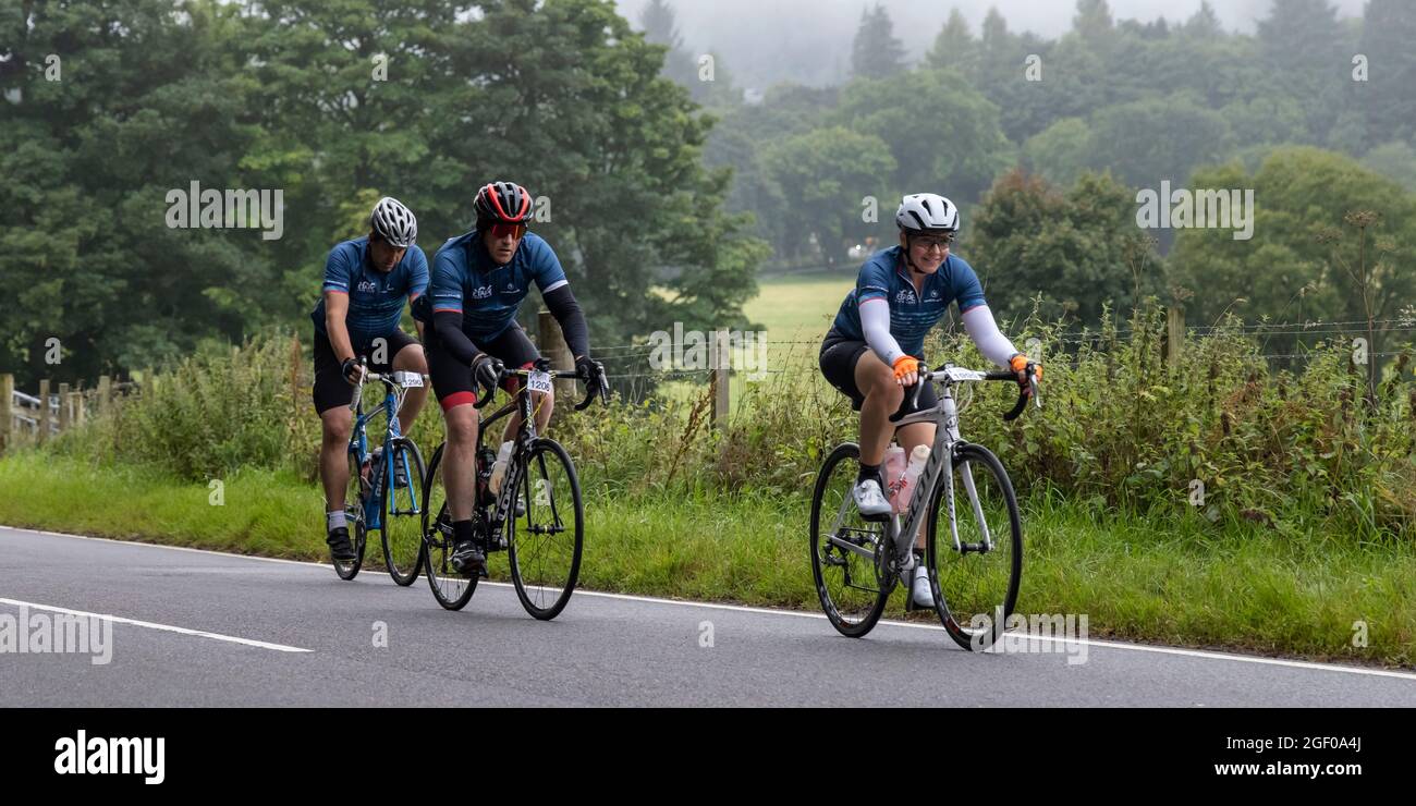 Fort Augustus, Scozia, Regno Unito. 22 agosto 2021. I ciclisti che prendono parte all'Etape Loch Ness hanno chiuso la strada ciclistica sportiva seguendo un percorso a 360 gradi di 66 miglia / 106 km intorno a Loch Ness, Scozia, partendo e finendo a Inverness. Migliaia di sterline saranno raccolti dai partecipanti al Macmillan Cancer Support, l'evento ufficiale di beneficenza. Questa immagine mostra i partecipanti che raggiungono il punto di metà strada vicino a Fort Augustus. Cliff Green/Alamy Foto Stock