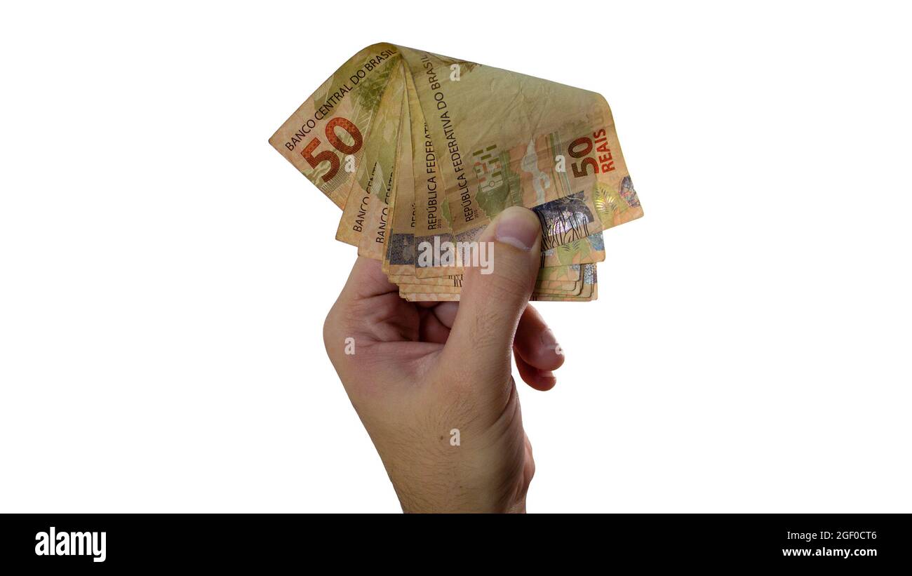 In possesso di denaro reale brasiliano isolato su sfondo bianco. Biglietto di cassa a mano maschile. Foto Stock