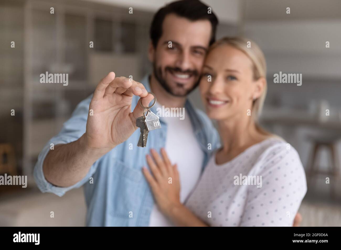 Felice coppia millenaria che mostra chiave da casa nuova Foto Stock