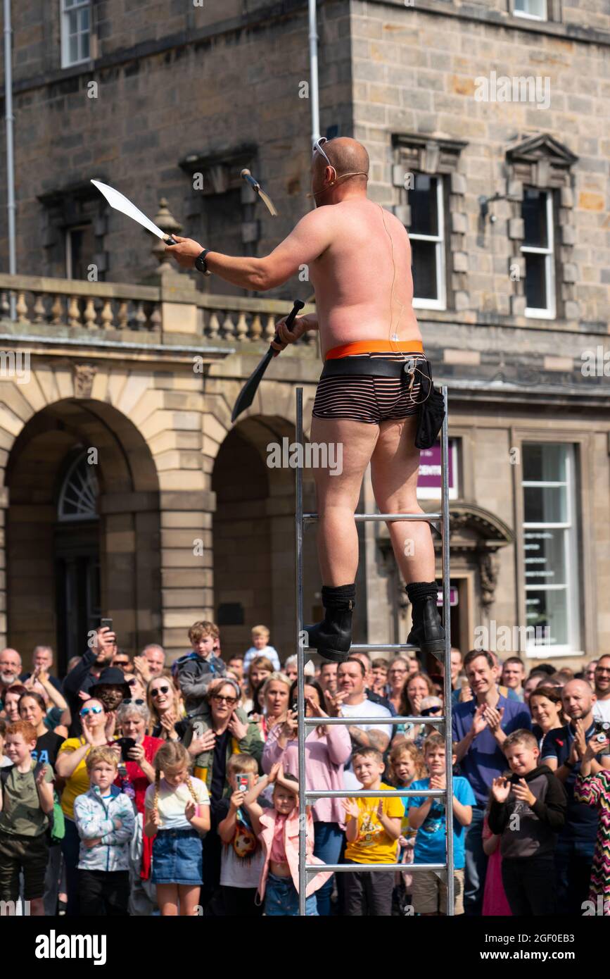 Edimburgo, Scozia, Regno Unito. 22 agosto 2021. L'artista di strada intrattiene una grande folla sul Royal Mile nella città vecchia di Edimburgo durante l'Edinburgh Fringe Festival 2021. Il bel tempo ha portato più visitatori in città questo fine settimana e più palcoscenici sono stati assegnati agli artisti di strada sul popolare Royal Mile. Iain Masterton/Alamy Live News. Foto Stock