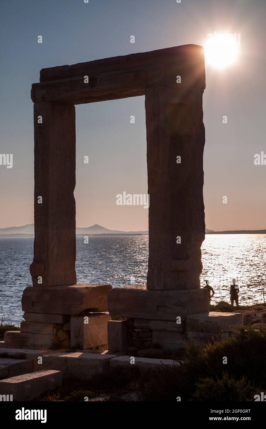 Guardando il sole scendere alla Portara o porta del tempio di Apollo , Naxos, Cicladi, Grecia Foto Stock