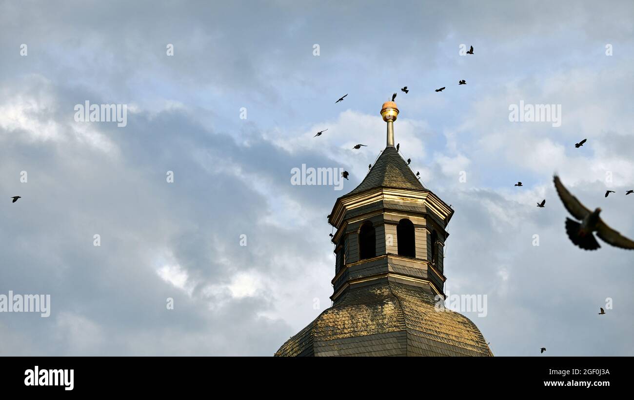 Gli uccelli si raccolgono sulla cima di una torre della chiesa durante le tempeste Foto Stock