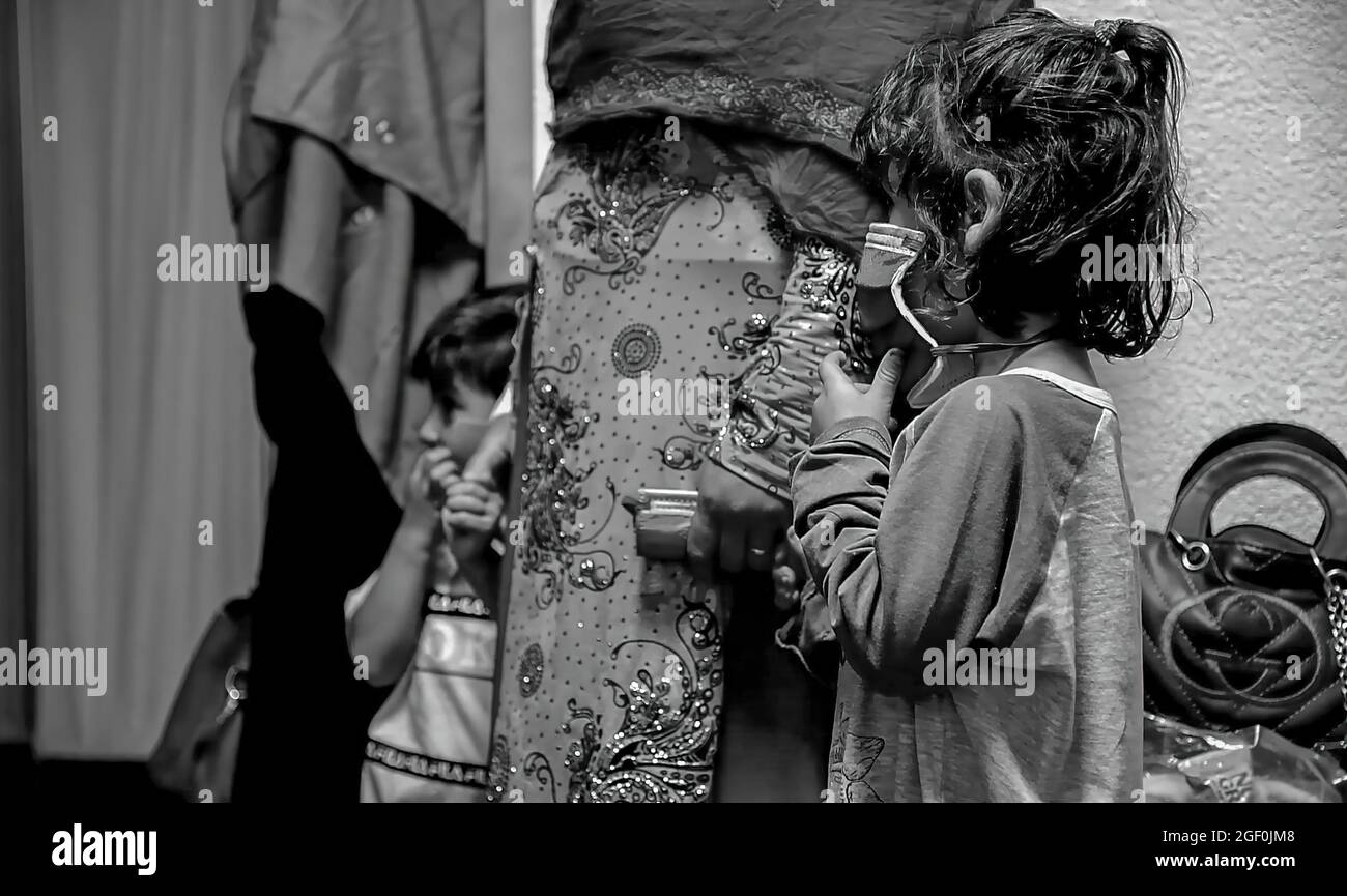 Una famiglia di evacuati afghani attende in linea presso il Joint Processing Readiness Centre della base aerea di Ramstein, Germania, 20 agosto 2021. La base aerea di Ramstein fornisce alloggi sicuri e temporanei per gli sfollati dall'Afghanistan come parte del Refuge Operation Allees. Questa operazione sta facilitando l'evacuazione rapida e sicura dei cittadini statunitensi, dei richiedenti di visti speciali per immigrati e di altri afghani a rischio dall'Afghanistan. FOTO DI CREDITO: US DoD via American PhotoArchive Foto Stock