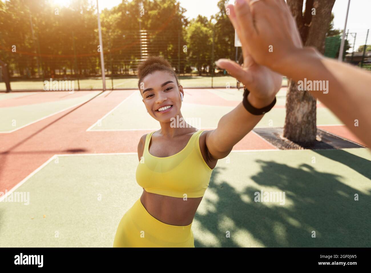 Donna nera sportiva che dà alto cinque dopo l'allenamento Foto Stock
