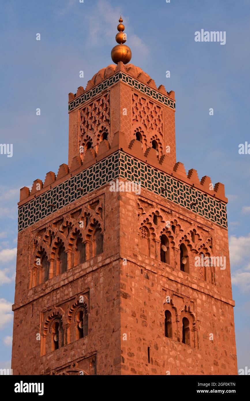 Minareto della Moschea di Koutoubia, alto 77 metri, decorato con motivi geometrici ad arco e sormontato da una guglia e orbe metalliche, Marrakech, Marocco, Africa. Foto Stock