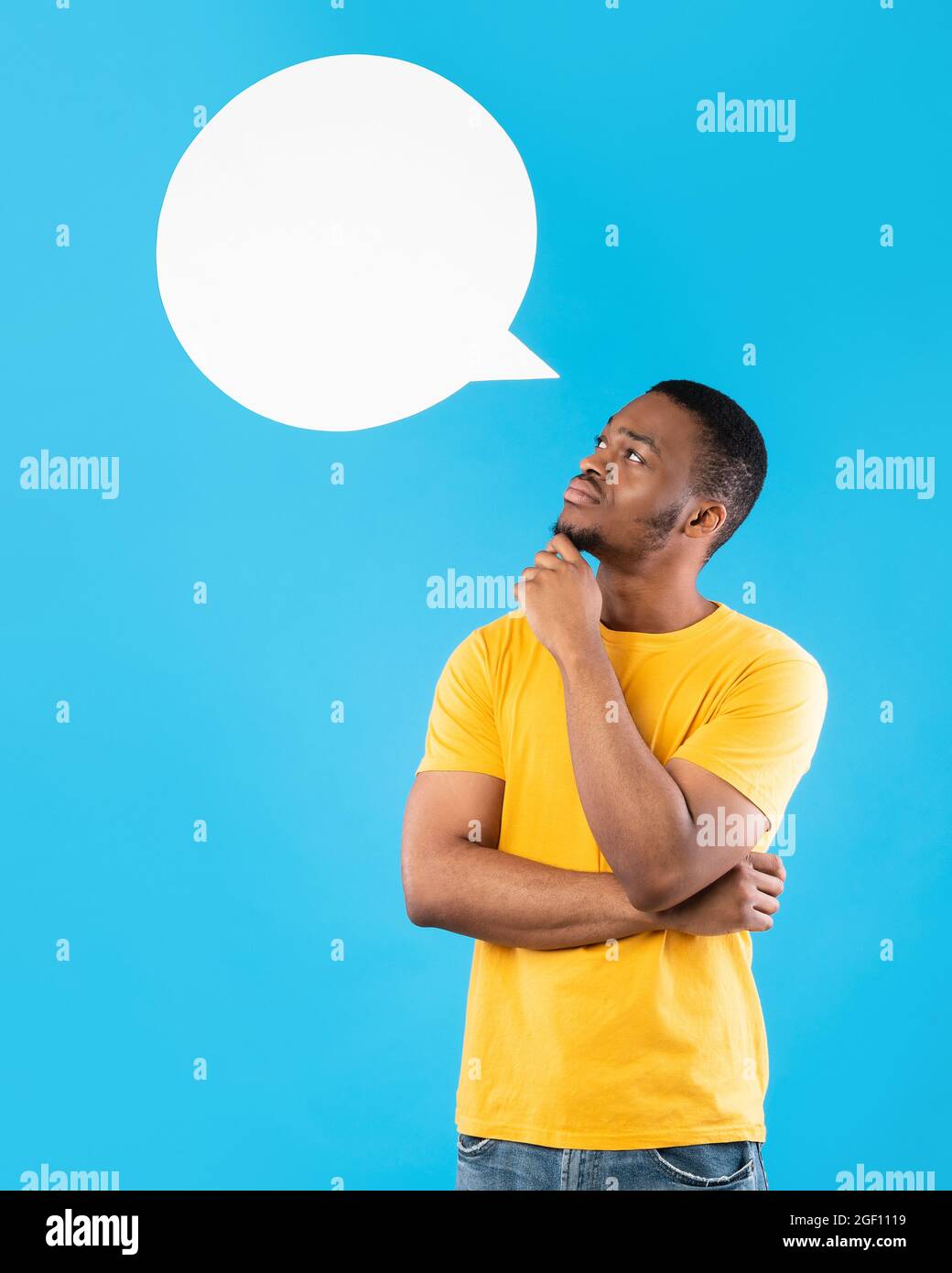 L'uomo africano che posa con il discorso Bubble sopra la testa, sfondo blu Foto Stock