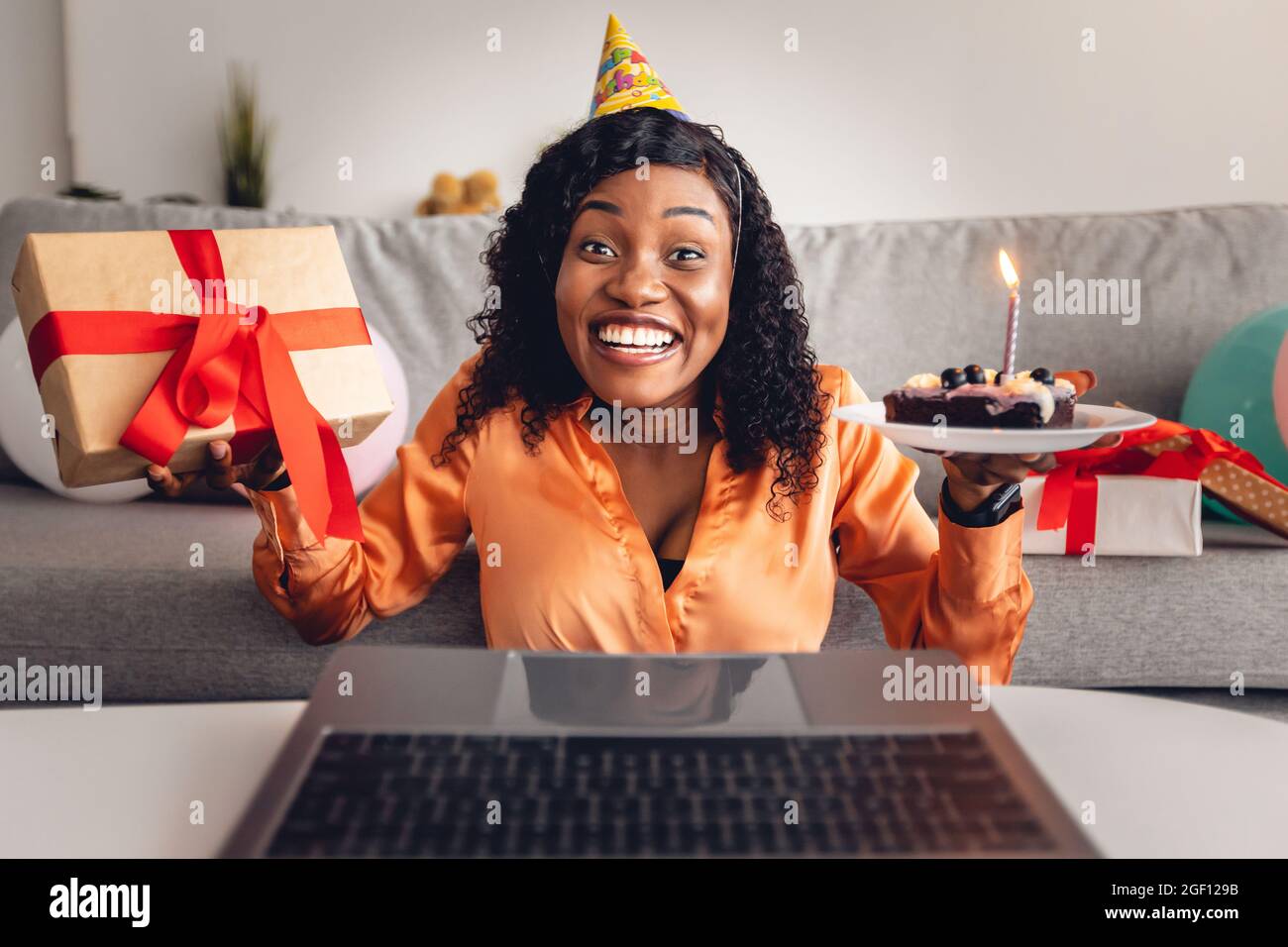 Black Female festeggia il compleanno al notebook con torta al coperto B-Day Foto Stock