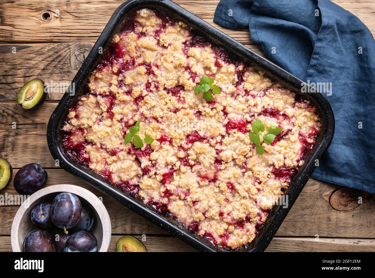 Succose fette di torta di susina con croccante striusella su sfondo rustico in legno Foto Stock