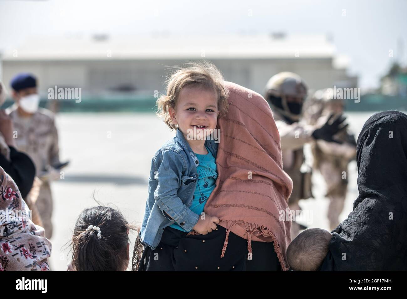 Kabul, Afghanistan. 21 Agosto 2021. Un bambino afghano sorride mentre esce per un volo di evacuazione all'aeroporto internazionale Hamid Karzai durante l'operazione Rifuge Allees 21 agosto 2021 a Kabul, Afghanistan. Credit: Planetpix/Alamy Live News Foto Stock