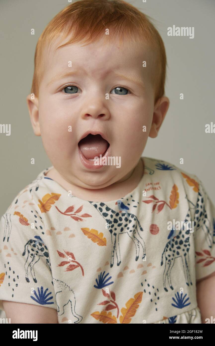 Un bambino dai capelli rossi con occhi blu di sei mesi Foto Stock