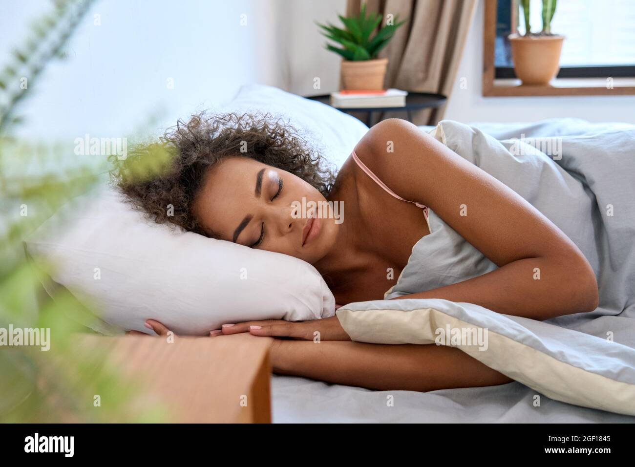 Giovane calma afroamericana donna che dorme bene in letto a casa. Foto Stock