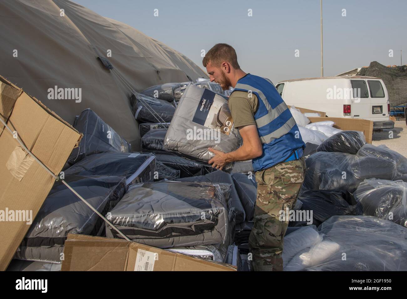 Un membro del servizio degli Stati Uniti scarica le scatole di biancheria da letto per gli evacuati qualificati il 21 agosto 2021, in un luogo non divulgato da qualche parte in Asia sud-occidentale. Nell'ambito dell'evacuazione dell'Afghanistan, gli sfollati sono partiti dall'aeroporto internazionale Hamid Karzai di Kabul, Afghanistan, su più aerei militari. Foto dello staff Sgt. Kylee Gardner/USA Air Force/UPI Credit: UPI/Alamy Live News Foto Stock