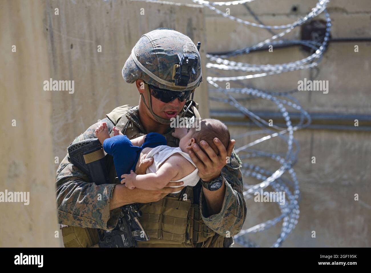 Kabul, Afghanistan. 22 agosto 2021. Una Marina statunitense assegnata alla 24a unità di spedizione marina (MEU) conforta un bambino mentre attendono la madre durante un'evacuazione all'Aeroporto Internazionale Hamid Karzai, a Kabul, Afghanistan, 21 agosto 2021. I membri del servizio degli Stati Uniti stanno assistendo il Dipartimento di Stato con un'operazione DI evacuazione non combattente (NEO) in Afghanistan. Foto di Lance CPL. Nicholas Guevara/U.S.A. Marine Corps/UPI Credit: UPI/Alamy Live News Foto Stock