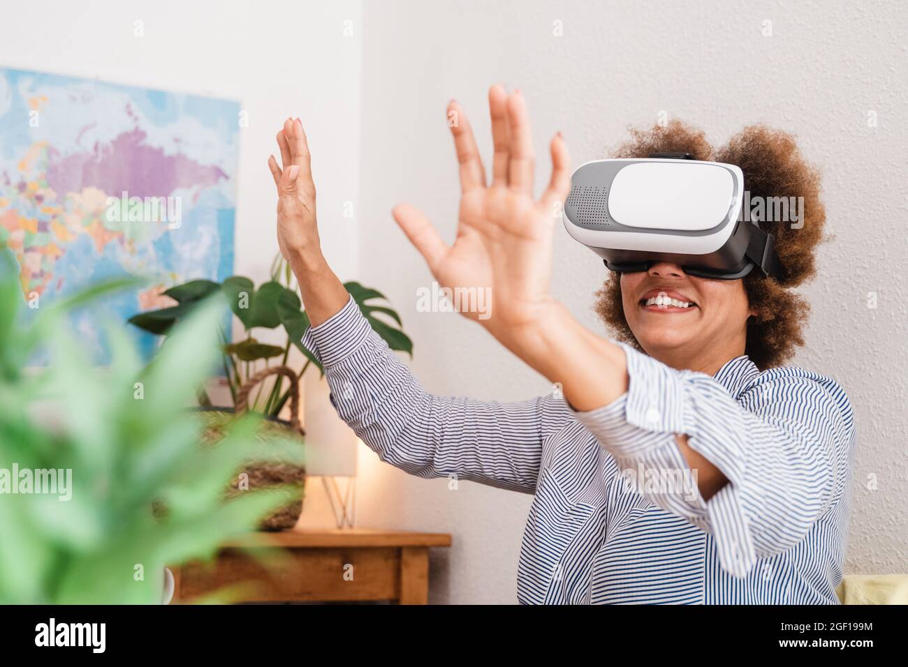 Donna africana anziana che utilizza il visore per realtà virtuale in ufficio - tecnologia business trend e stile di vita - Focus sugli occhiali per realtà virtuale Foto Stock