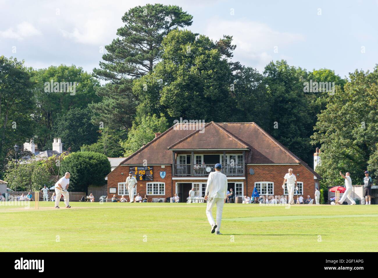 Partita di cricket locale e Pavilion, Chobham Cricket Club Ground, Chobham, Surrey, Inghilterra, Regno Unito Foto Stock