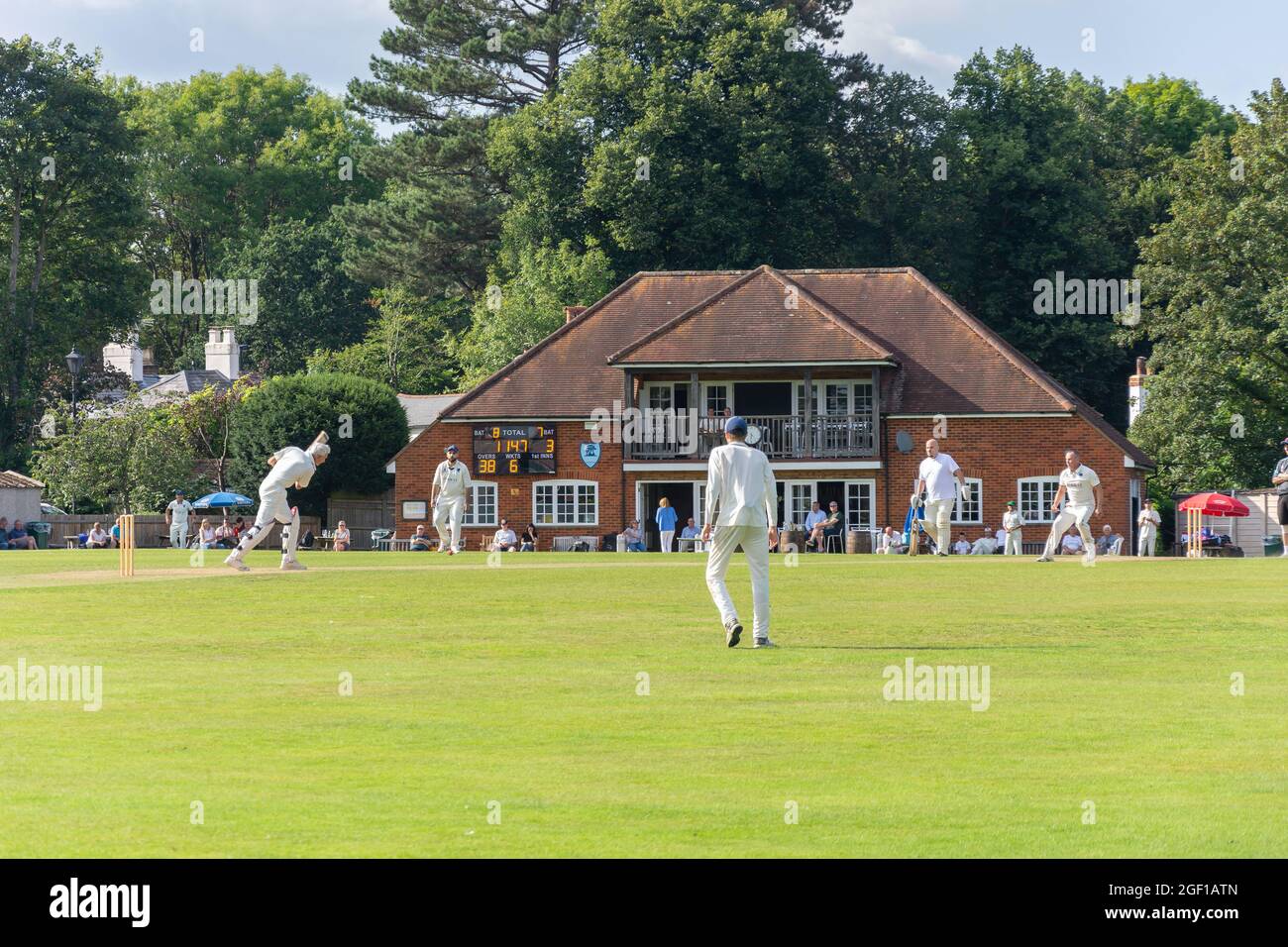 Partita di cricket locale e Pavilion, Chobham Cricket Club Ground, Chobham, Surrey, Inghilterra, Regno Unito Foto Stock